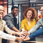 group of co-workers with hands together