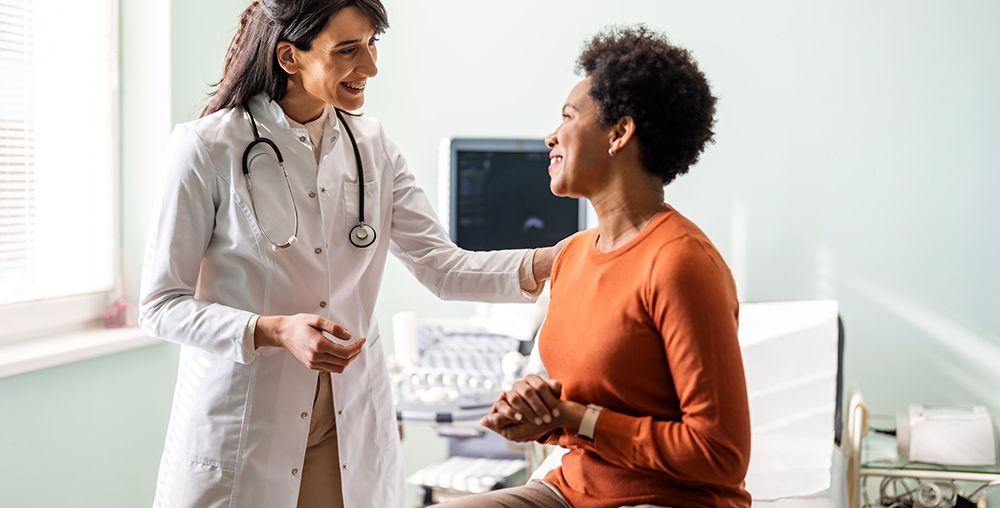 female doctor speaking to a smiling female patient