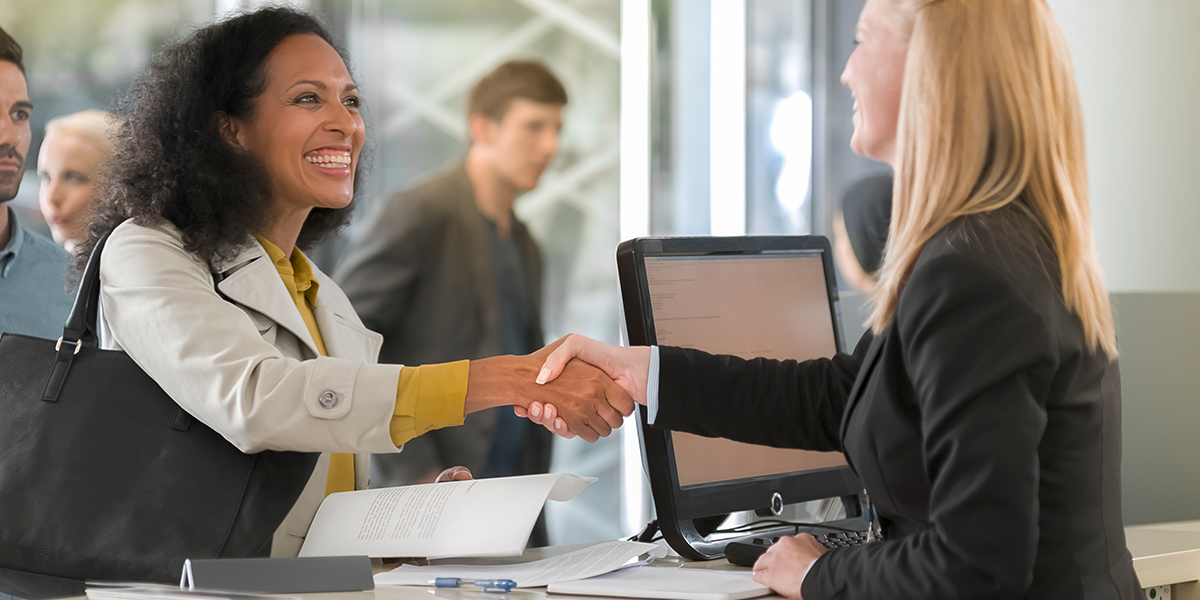 business woman shaking hands with smiling customer