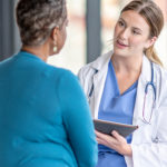 Female doctor speaking with female patient