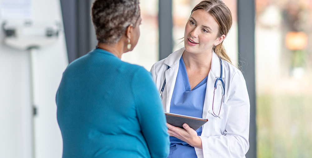 Female doctor speaking with female patient