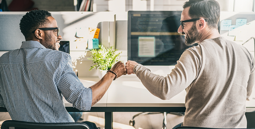 two casual businessmen fist bumping