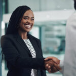 African American business woman shaking hands with another business man