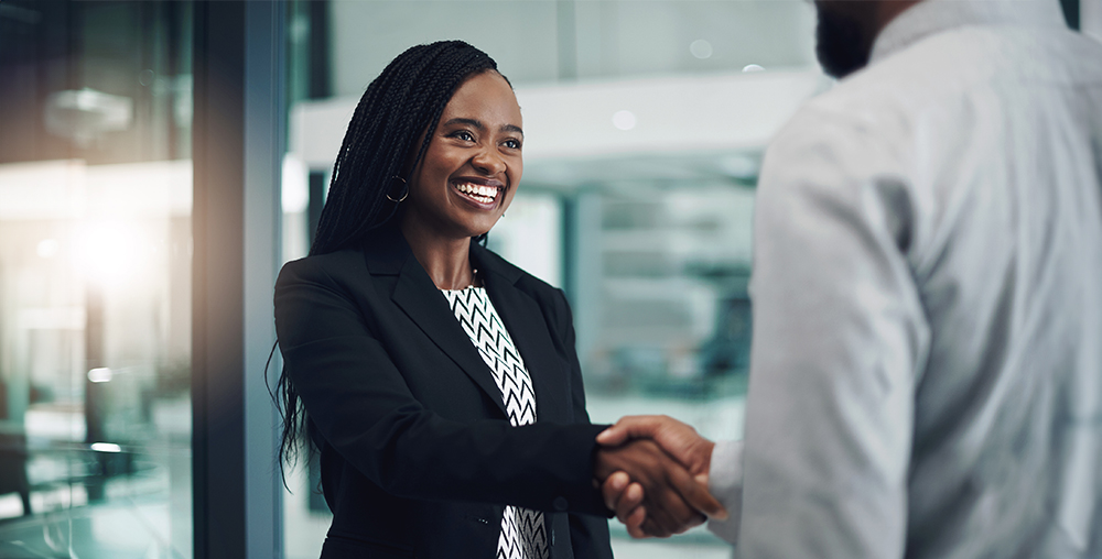 African American business woman shaking hands with another business man