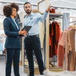 two retail associates talking amongst clothes