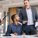 adult male manager leading discussion at a table of professionals