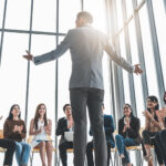 business man talking infront of a small group