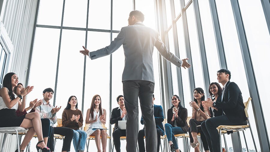 business man talking infront of a small group