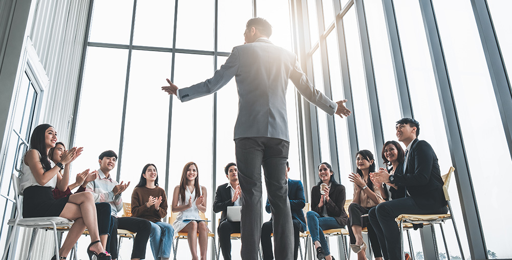 business man talking infront of a small group