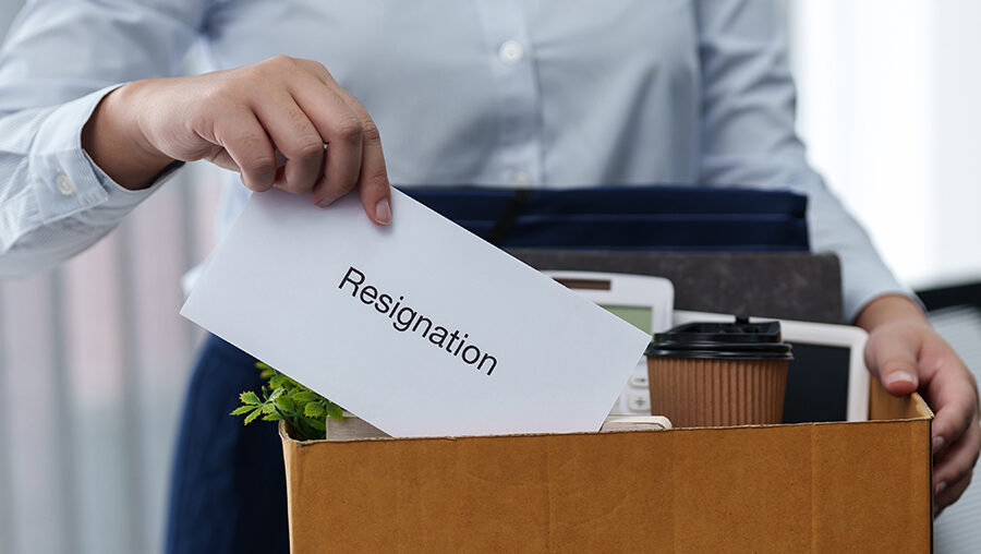 person putting resignation letter into box