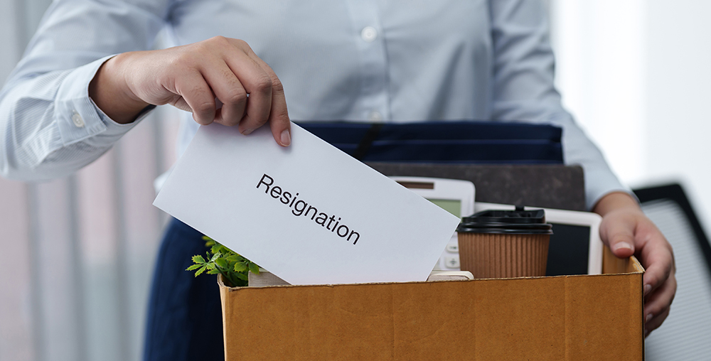 person putting resignation letter into box